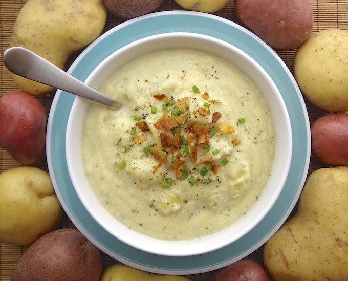 Vegan creamy potato cauliflower soup topped with coconut bacon and green onions.