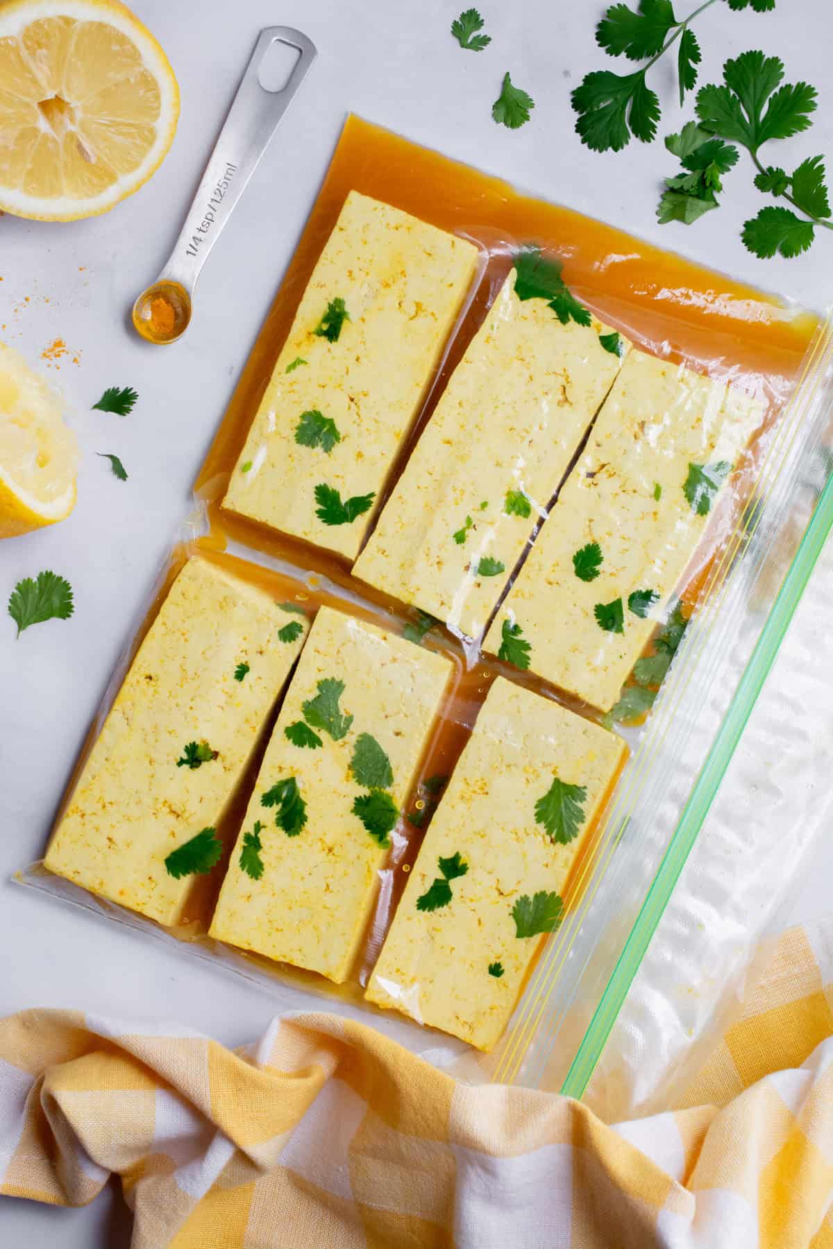 Sliced tofu with lemon marinade in a ziplock bag.