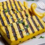 Slices of grilled lemon tofu on a serving plate.