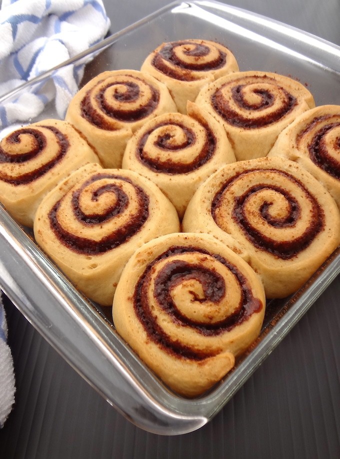 Refined sugar free vegan cinnamon rolls in a glass dish after baking.