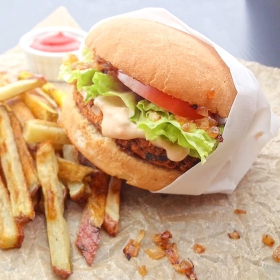 A vegan in-n-out style burger with homemade fries and small side of ketchup