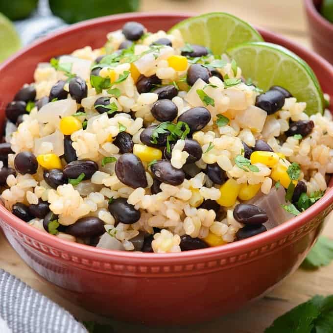 A bowl of brown rice, black beans, corn and onion.