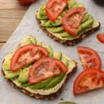 Toast topped with hummus, avocado, and tomato.
