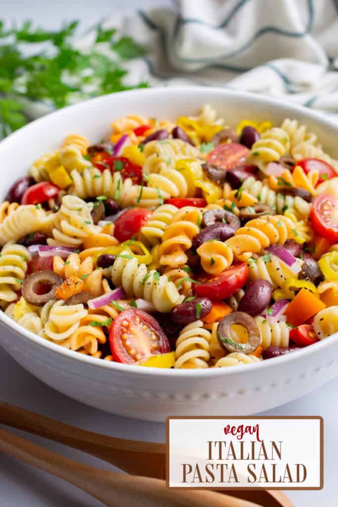 A white bowl of vegan pasta salad with kidney beans and veggies.