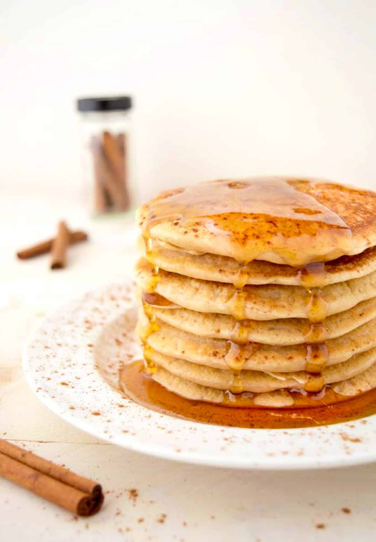 A stack of cinnamon pancakes topped with maple syrup.