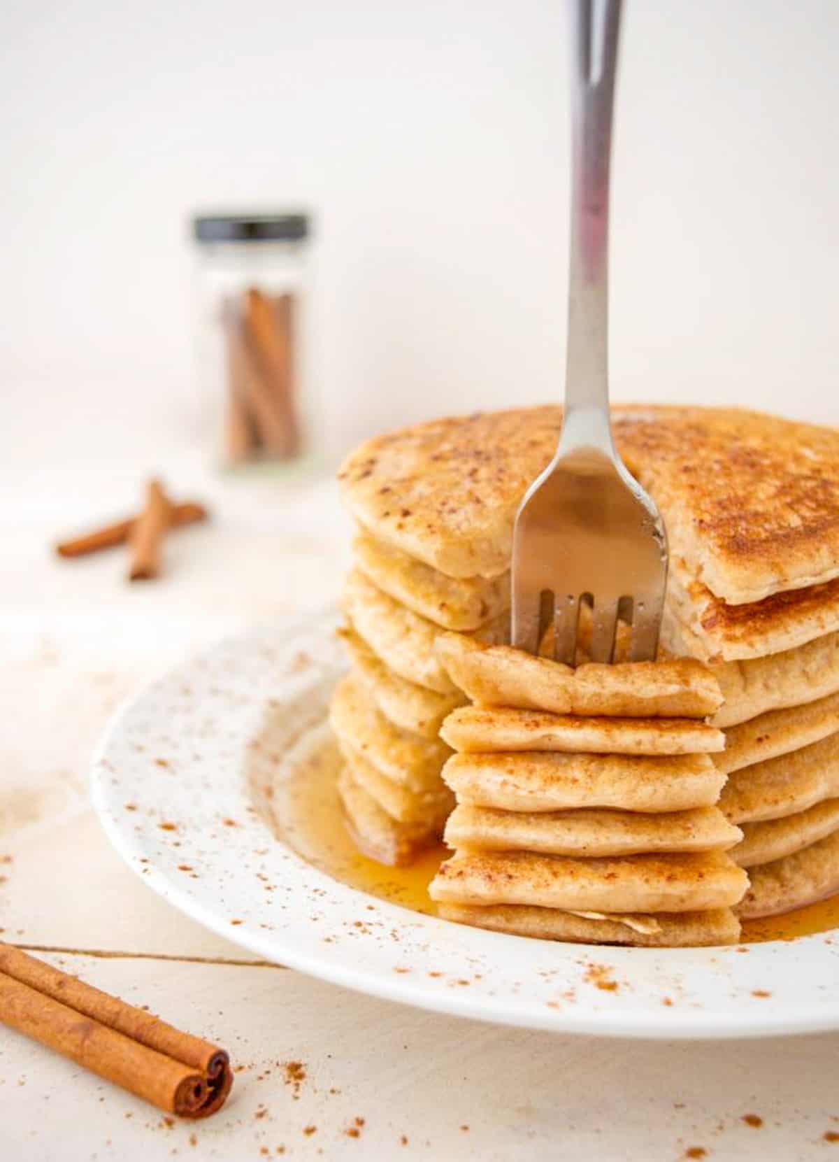 A fork stuck into a stack of vegan cinnamon pancakes.