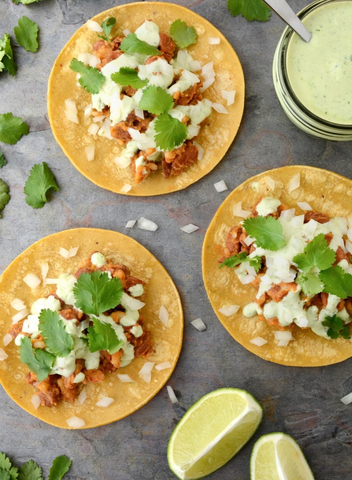 Vegan Tacos with Cilantro Lime Sauce are gluten-free and oil-free. These healthy 20 minute vegan tacos are so easy to make and only take one pan! The filling is made with seasoned pinto beans and rice. Then the tacos are topped with a tangy cilantro lime sauce.