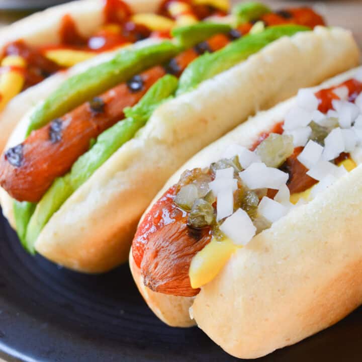 Vegan carrot hot dog topped with mustard, ketchup, relish, and diced white onion.