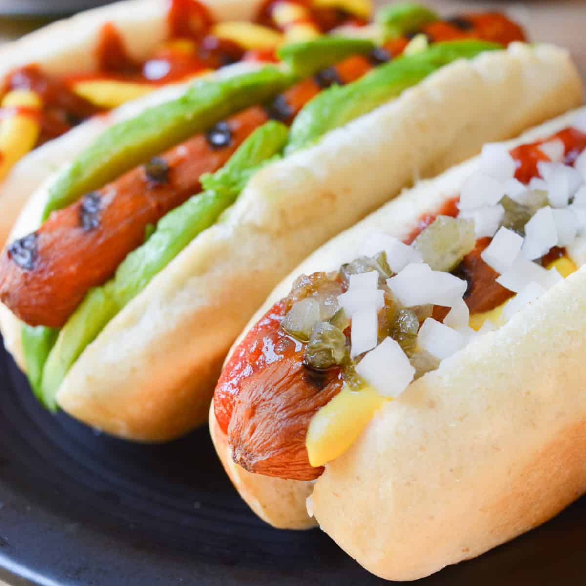 Vegan carrot hot dog topped with mustard, ketchup, relish, and diced white onion.
