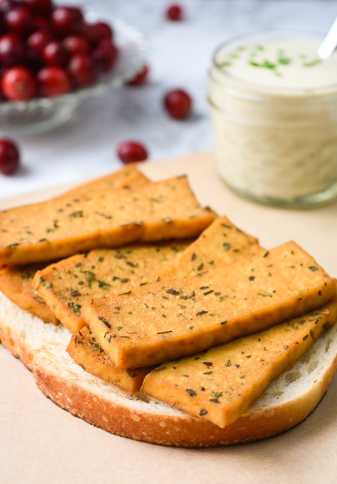 Vegan Holiday Sandwich- Herb tofu on sourdough bread with a jar of savory herb dressing.