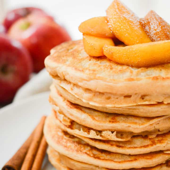 Vegan pancakes topped with cooked cinnamon apples.