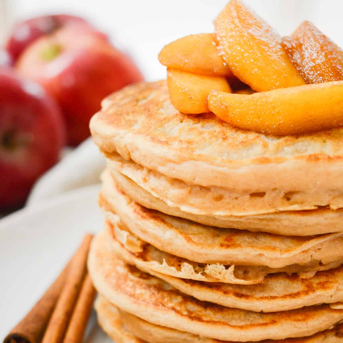 A stack of vegan pancakes topped with cinnamon apples.