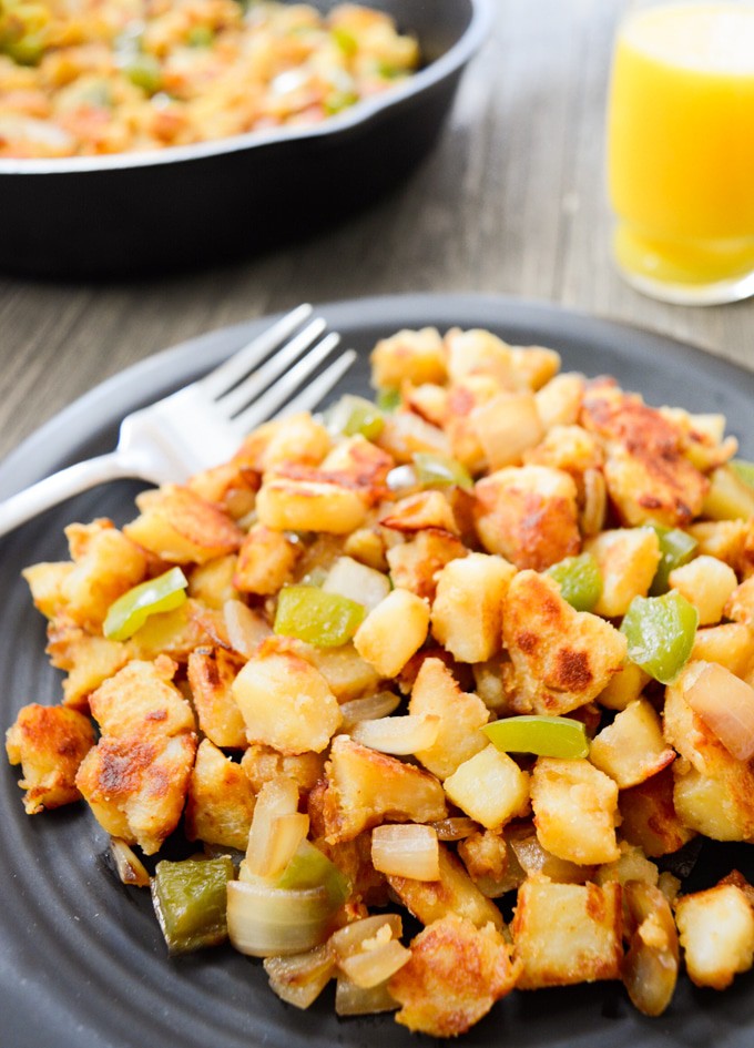 Breakfast potatoes on a plate with fork.