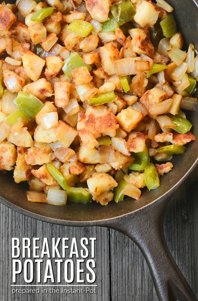 Browned breakfast potatoes with onions and bell peppers in a cast iron skillet.