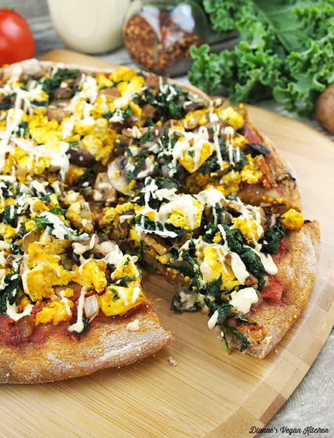vegan breakfast pizza with a slice cut out.