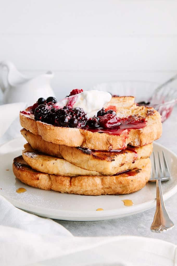French toast stacked and topped with berries.