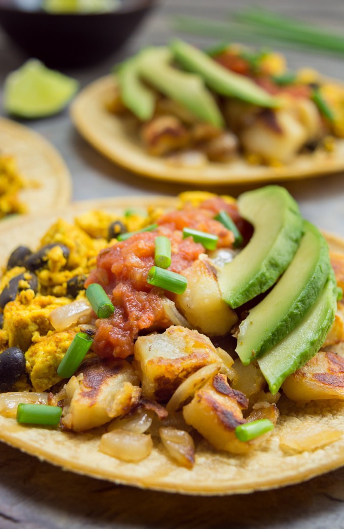 Vegan Breakfast Tacos- A corn tortilla filled with tofu scramble, black beans, breakfast potatoes, salsa, avocado slices and green onions.