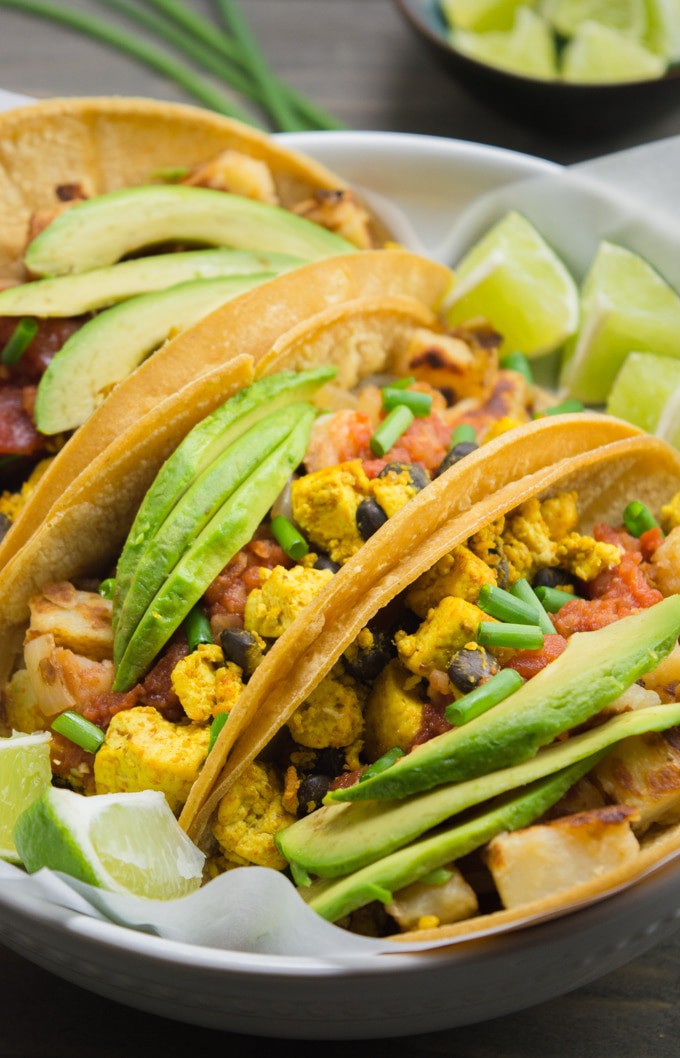 3 Vegan Breakfast Tacos topped with avocado slices and salsa.