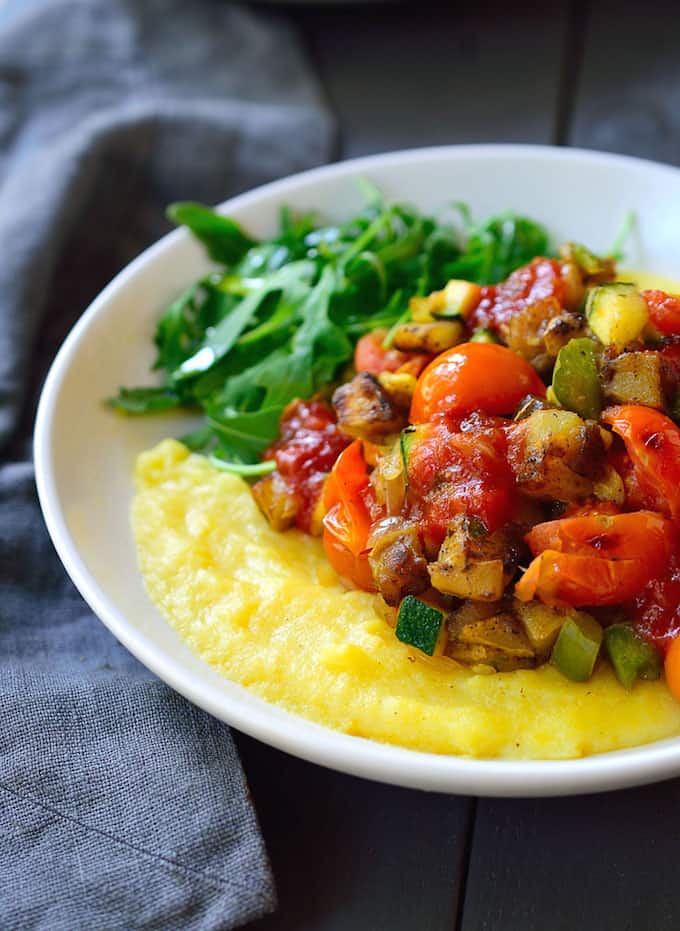 a bowl of breakfast polenta topped with potatoes.