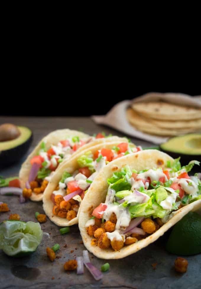 3 vegan chickpea soft tacos on homemade soft flour tortillas. They're stuffed with taco seasoned chickpeas, lettuce, onions, tomatoes and a cheesy vegan ranch dressing.