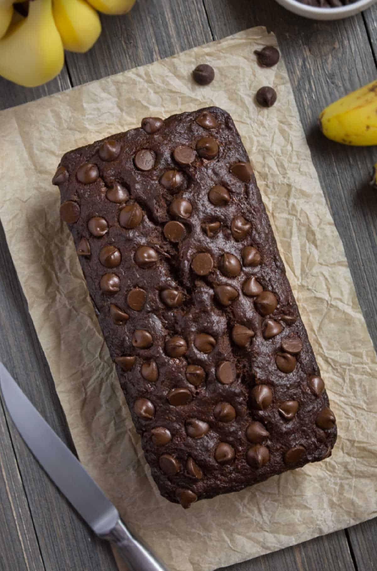 A loaf of vegan chocolate banana bread topped with chocolate chips.