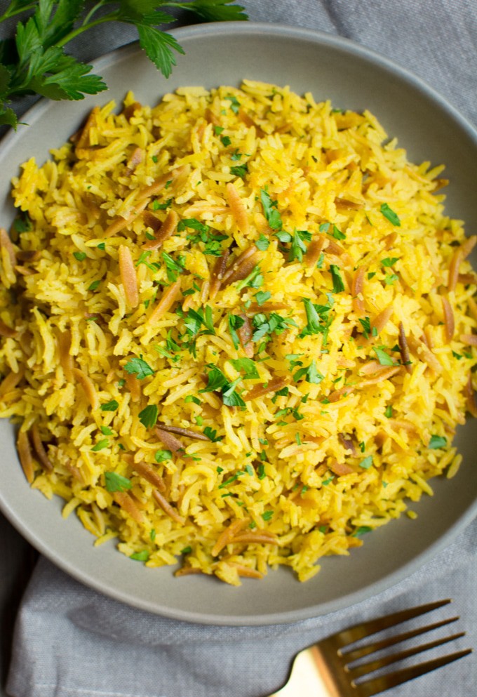 Overhead angle of Instant-Pot rice pilaf on a gray plate topped with parsley.