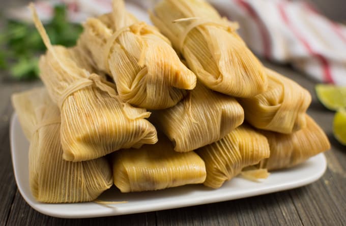 Vegan tamales stacked on a plate.