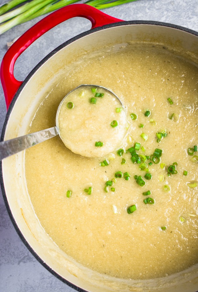 vegan cauliflower leek soup being served with a ladle.