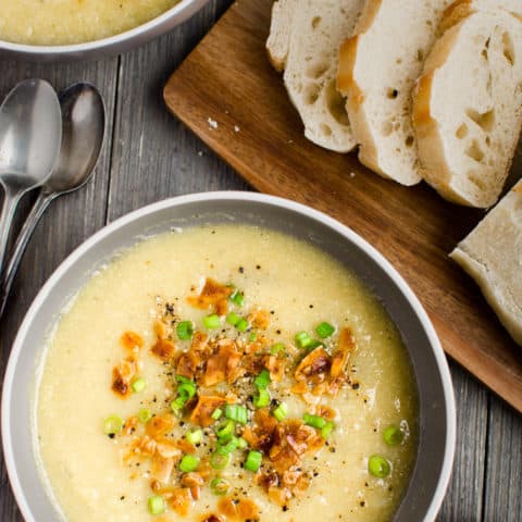 2 bowls of vegan Cauliflower Leek Soup served with a loaf of french bread.