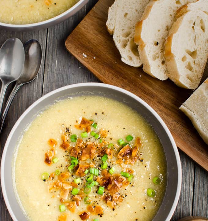 2 bowls of vegan Cauliflower Leek Soup served with a loaf of french bread.