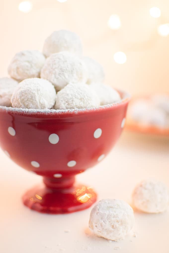 Vegan snowball cookies in a red holiday dish.