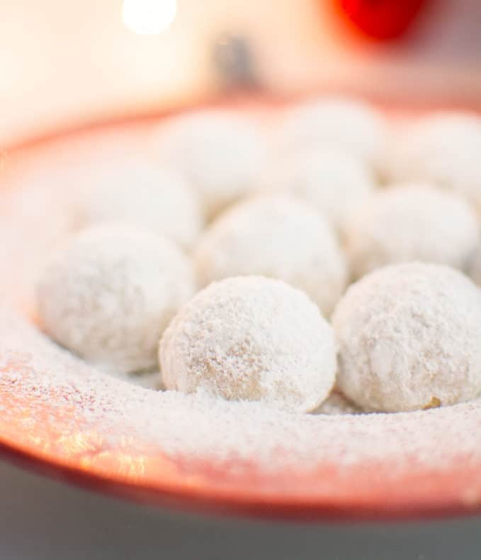 Vegan snowball cookies on a red serving plate.