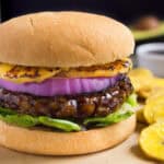 Vegan Hawaiian burger with lettuce, red onion, and grilled pineapple.