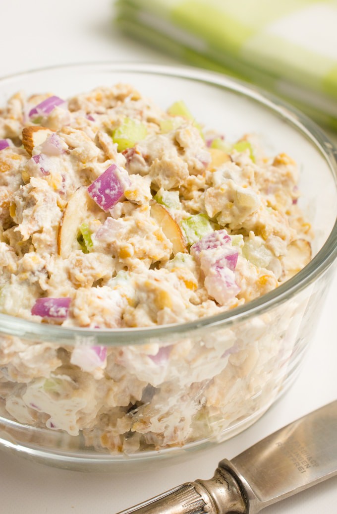 Vegan chicken salad (jackfruit, chickpeas, mayo, almond slivers, onion and celery) in a glass bowl.