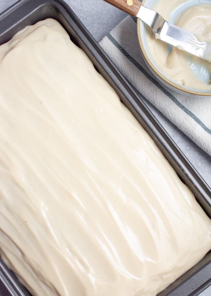 Pumpkin spice cake with cashew cream cheese frosting in a baking pan.