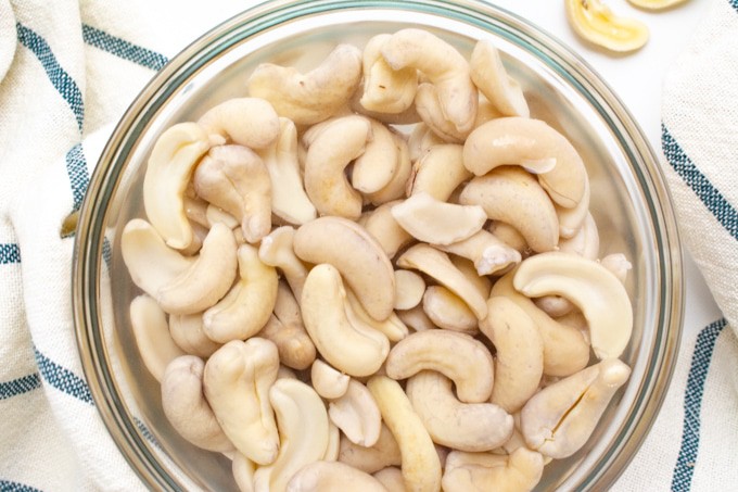 Raw cashews soaked overnight in a glass bowl. 