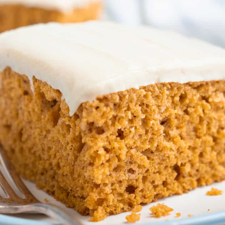 A slice of vegan pumpkin cake topped with cashew frosting.