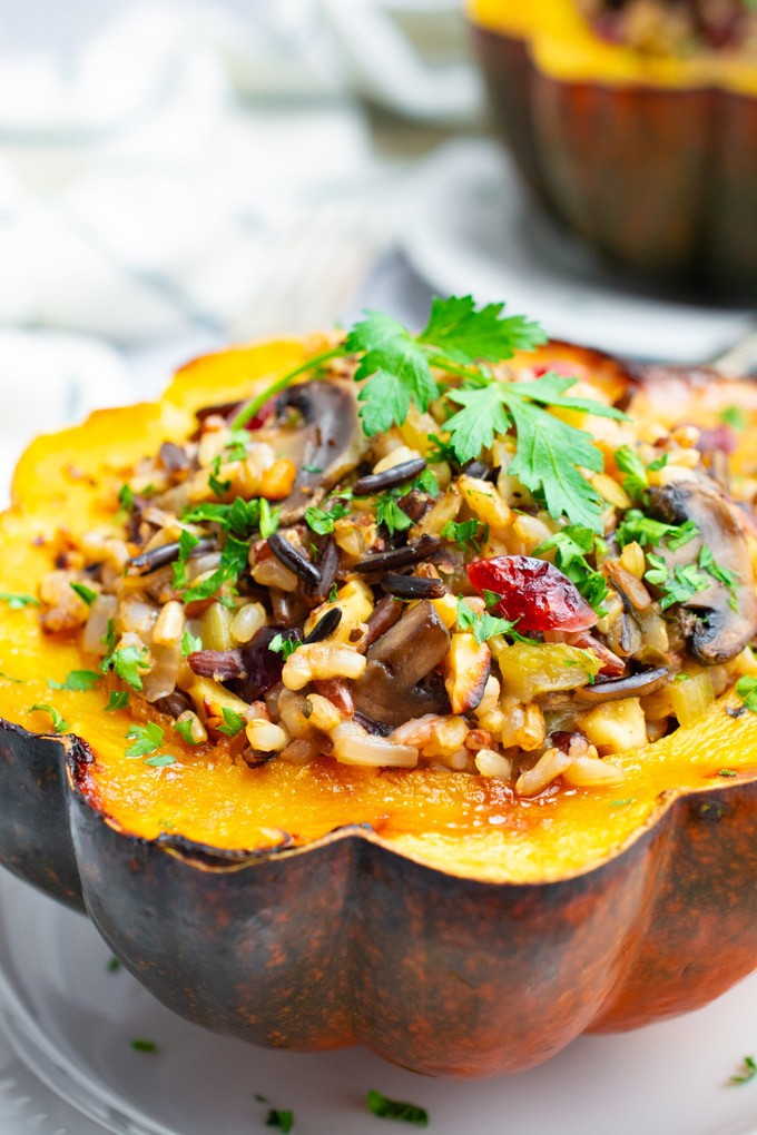 Vegetarian stuffed acorn squash filled with wild rice on a white plate