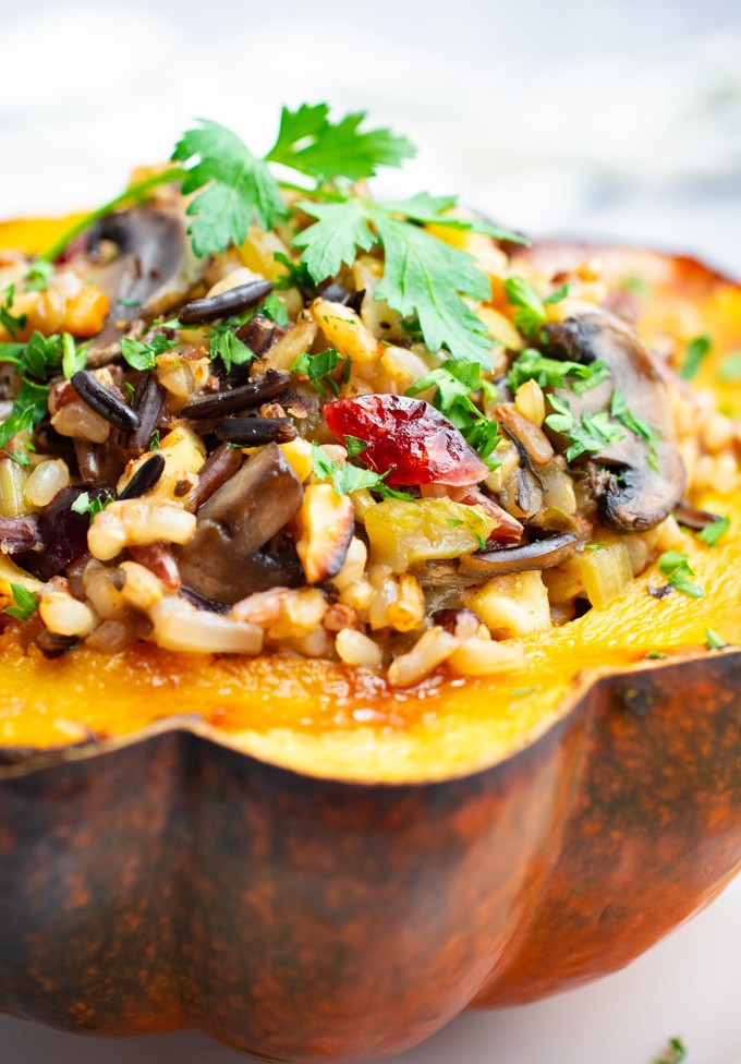 Roasted acorn squash stuffed with wild rice, mushrooms, cranberries and topped with a fresh parsley leaf.