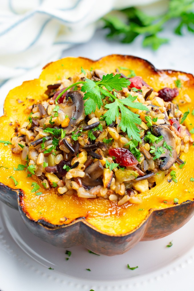 Flower shaped wild rice stuffed acorn squash on a white plate.