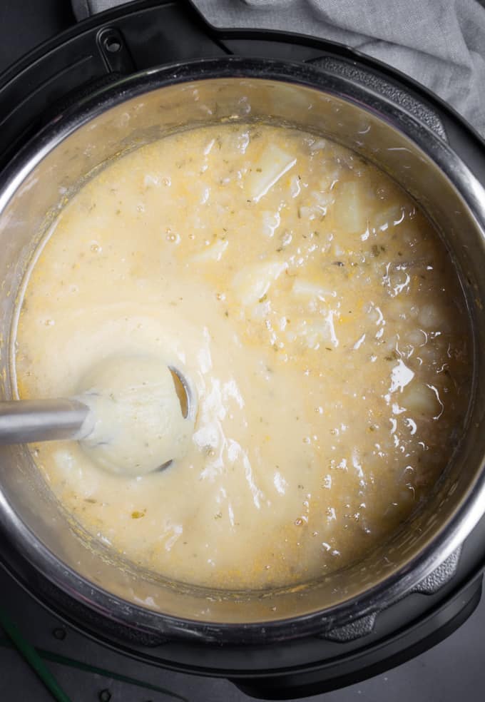 An immersion blender blending potato soup in the Instant Pot.