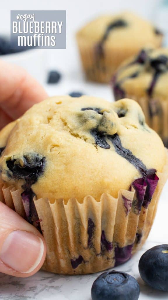 A hand grabbing a muffin.