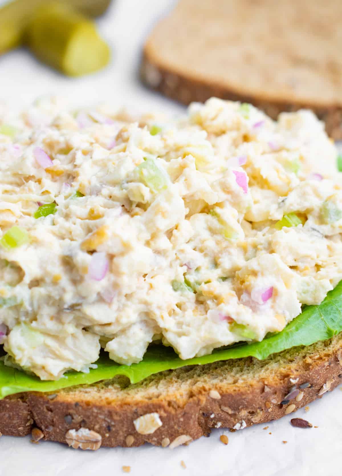A slice of bread topped with lettuce and vegan tuna salad.