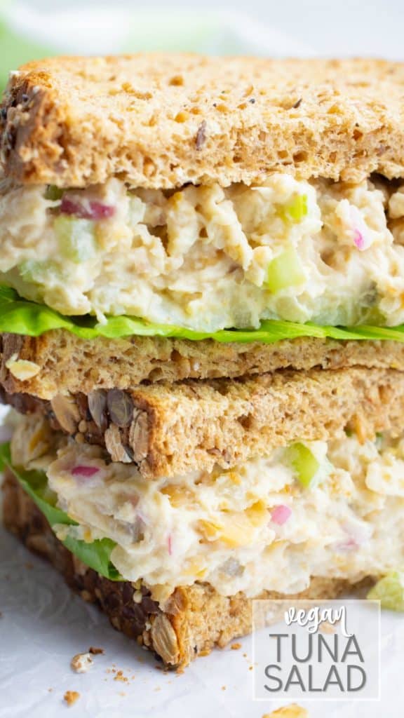 Vegan tuna salad sandwich on wheat bread cut in half and stacked.