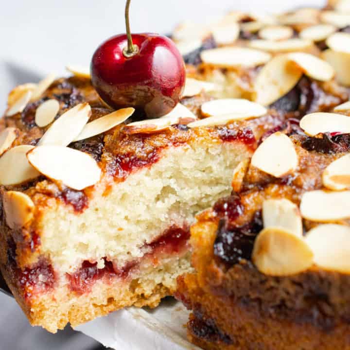 Vegan cherry coffee cake topped with toasted almond slivers.