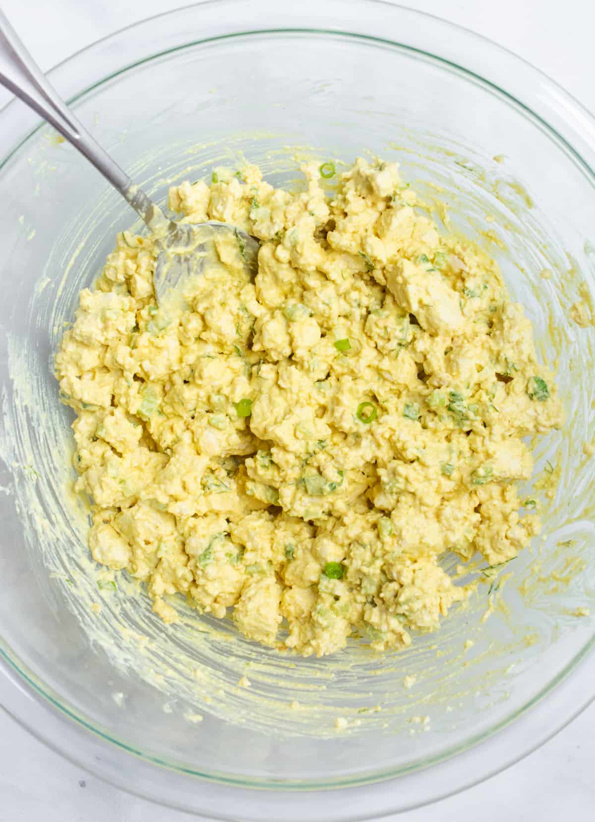 Mixed tofu "egg" salad in a glass bowl.