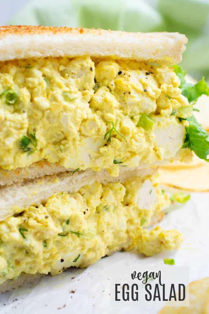 Vegan egg salad sandwich cut in half and stacked.