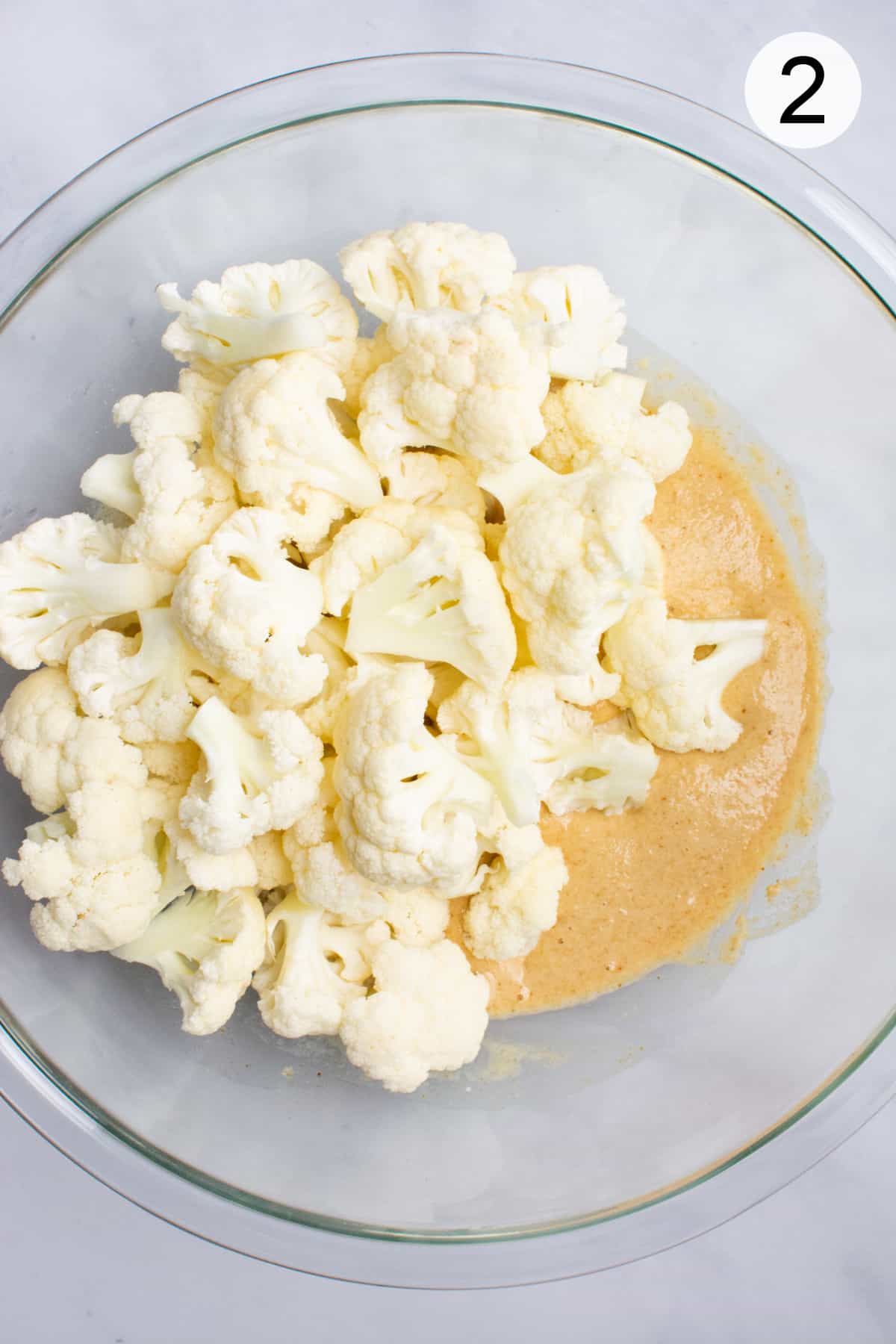 Cauliflower in a bowl of batter.