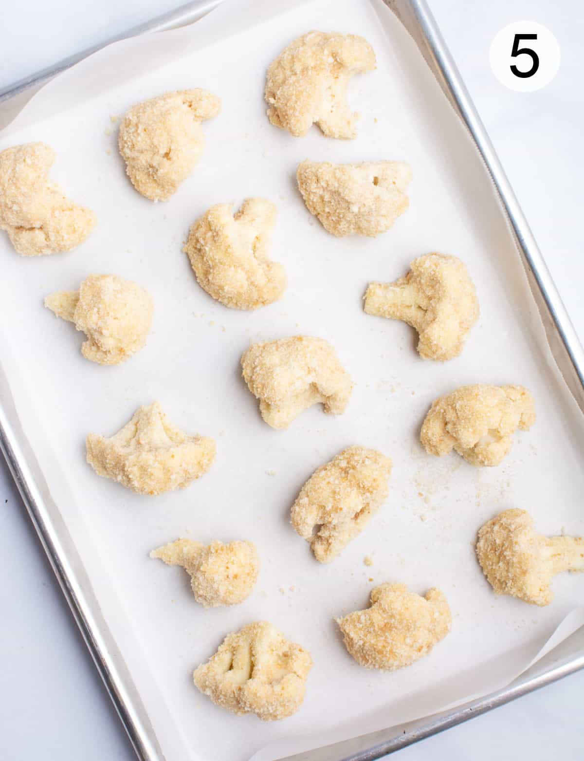 A pan of breaded cauliflower before baking.