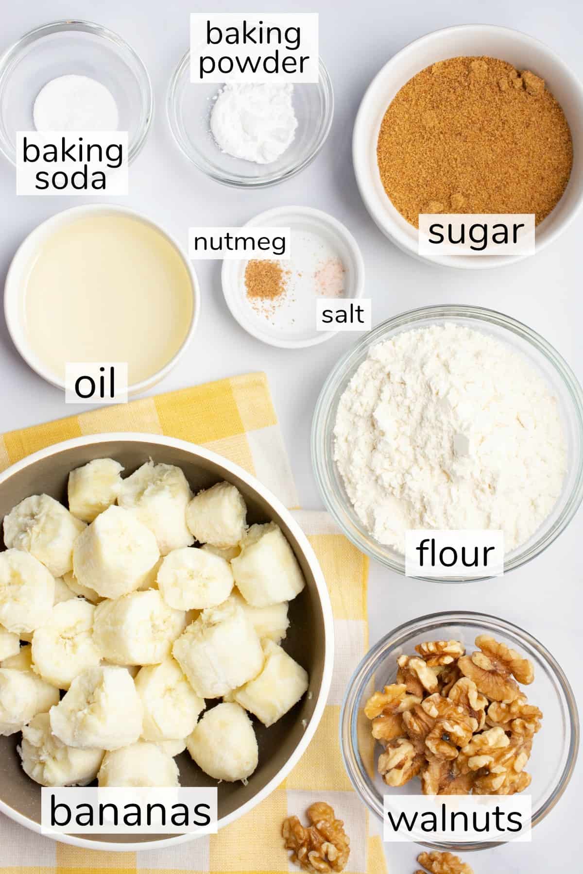 Labeled ingredients in bowls for vegan banana bread.